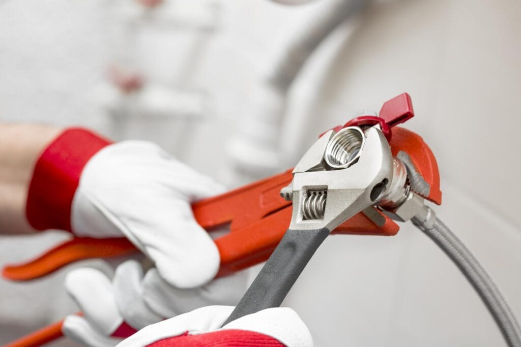 Plumber holding pipe wrenches for an emergency repair in Upper Darby