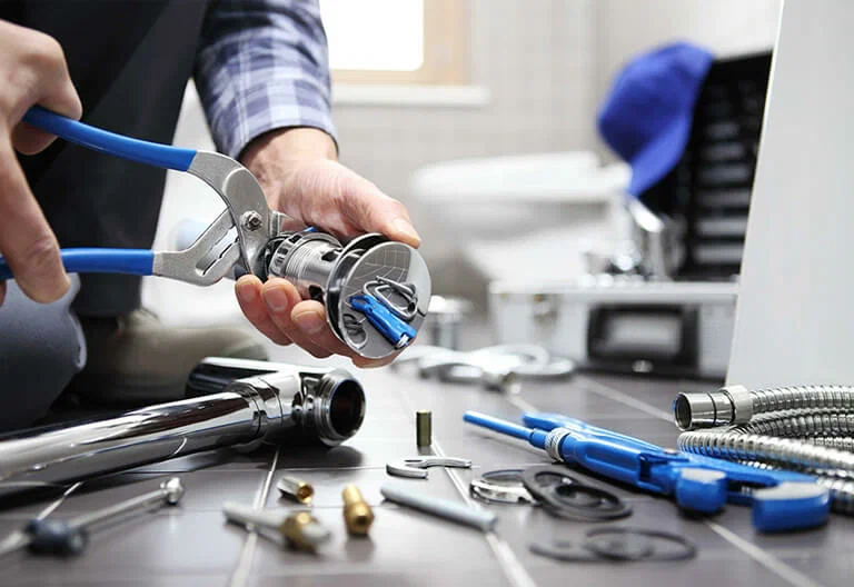 Technician repairing a plumbing fixture with professional tools in Upper Darby