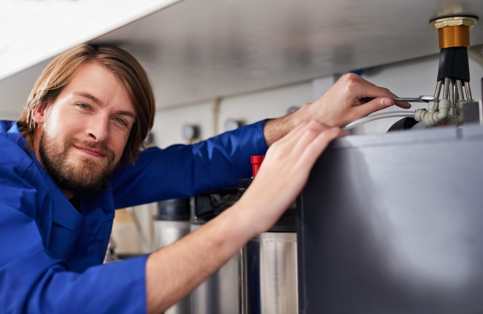 Technician servicing a residential water heater tank in Upper Darby